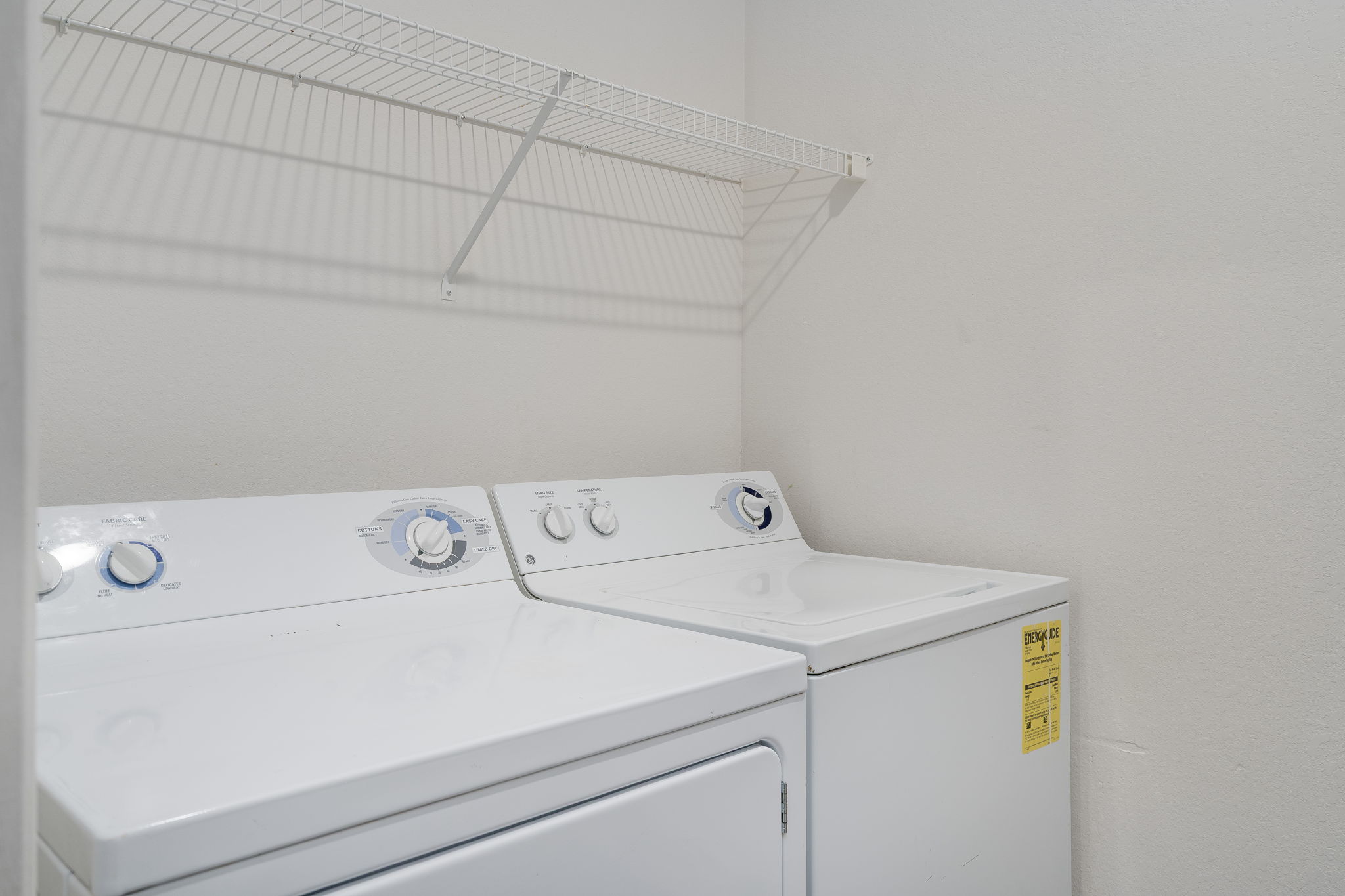 A white washing machine and dryer in a laundry room.